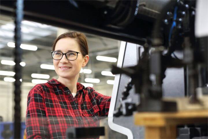 Frau mit Brille sitzt an ihrem Schreibtisch