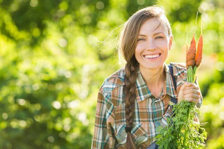 junge Dame in einem Blumenbeet