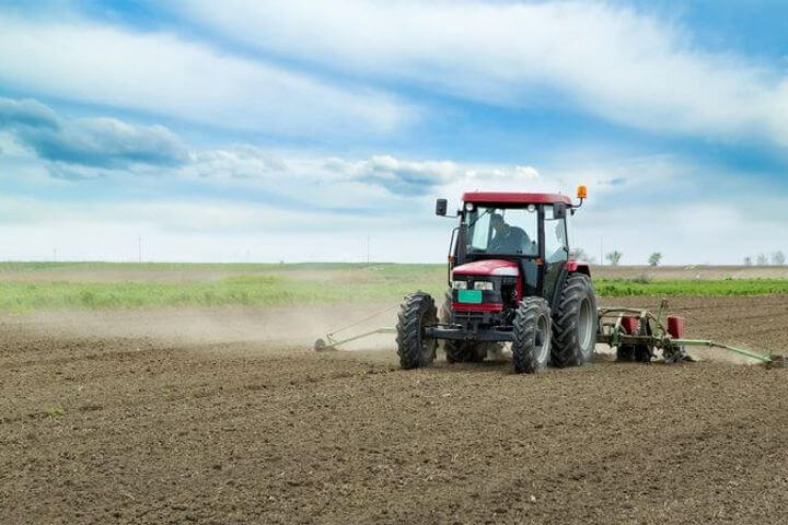 Traktor saeht auf einem Feld