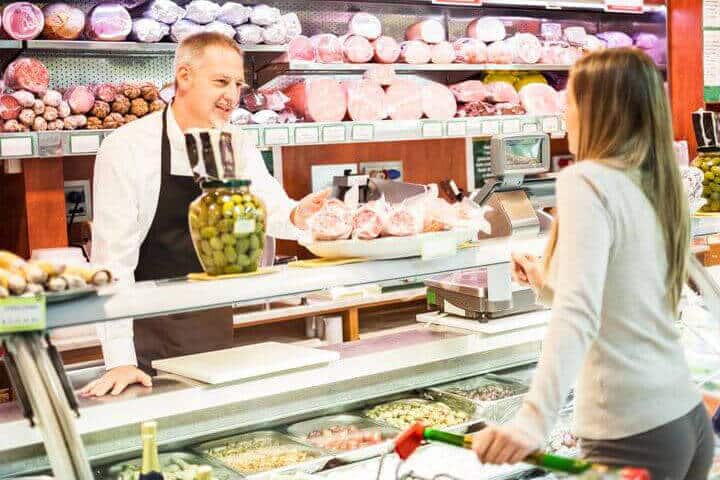 Wurstverkaeufer hinter der theke verkauft