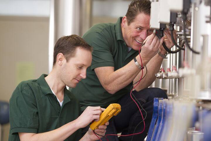 zwei männer beim reparieren eines Silos