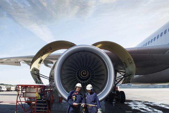 zwei luftfahrzeugtechniker stehen vor Flugzeugturbine