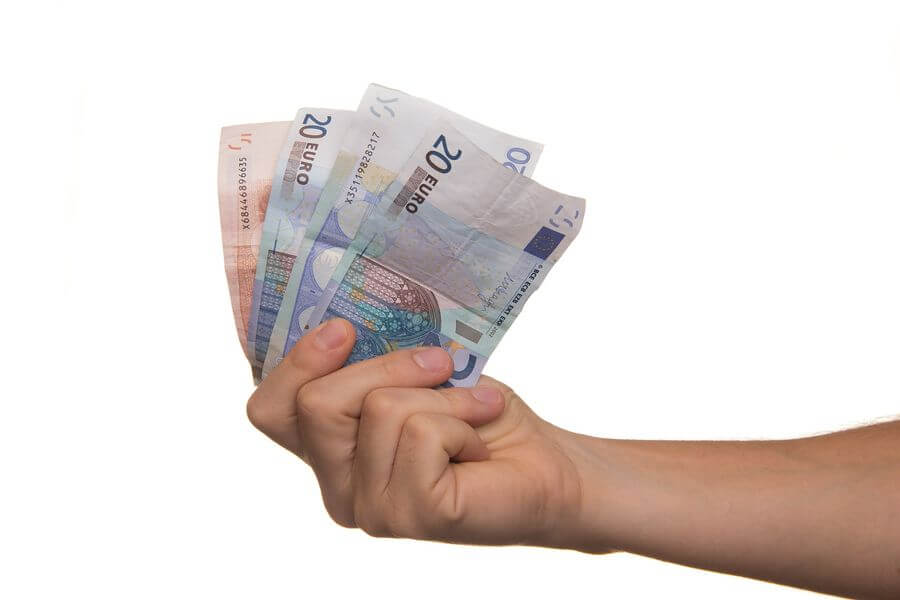 Lehrlingsportal.at Eine Hand hält mehrere Euro-Banknoten in verschiedenen Stückelungen vor einem weißen Hintergrund.