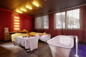 Wellnessbereich mit zwei Massageliegen und Badewanne