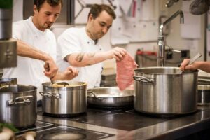 Köche panieren Schnitzel und kochen Suppe