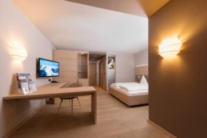 Hotelzimmer in Holz mit Doppelbett und TV