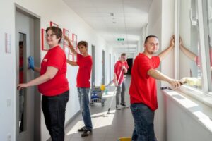 Lehrlinge reinigen Flur, Fenster und Türen