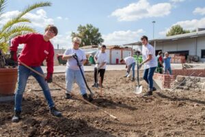 Lehrlinge schaufeln auf Baustelle