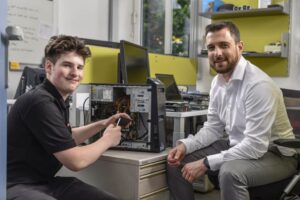 Ausbildner mit Lehrling arbeitet an einem PC-Tower