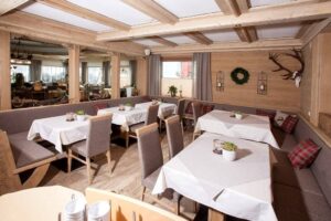 Ansicht Restaurant mit weiß eingedeckten Tischen und Dekogeweih