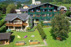 Aussenansicht Hotelgebäude mit Gartenanlage im Sommer