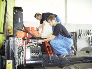 Lehrlinge arbeiten an Anlage beim LKW