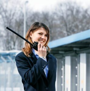 Lehrmädchen im Sakko mit Walkie-Talkie