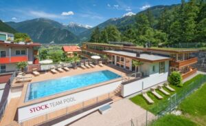 Aussenansicht Hotelanlage mit Outdoorpool und Bergkulisse im Sommer